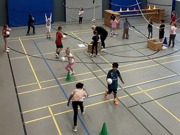 Bild von Kindern, die Handball&uuml;bungen in der Turnhalle machen
